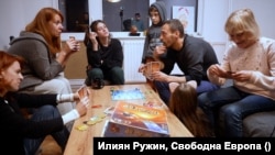 Виктория, Лилия, Ника, Ярик, Льоша, Валя и Арина (от ляво надясно) играят Dixit в една от семейните вечери в българския им дом