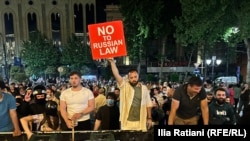 Протестиращ в Грузия държи табела с надпис - "Не на руския закон".