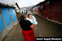 A woman carries her child at the Zitkovac camp.