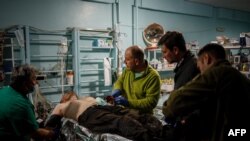 Medicii militari acordă primul ajutor unui militar ucrainean rănit la un punct de stabilizare medicală de pe linia frontului, în apropierea orașului Bahmut din regiunea Donețk, mai devreme în acest an.