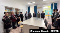 Askar Kazybayev (sixth from the left), a ruling Amanat party candidate running to head the Oyil district, campaigns at a school in Oyil village on October 24.