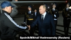 Russian security operative Vadim Krasikov (left) being welcomed to Russia by President Vladimir Putin on August 1