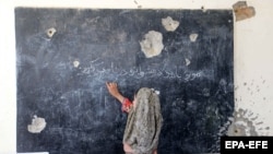 یوه ماشومه په یوه جنګ ځپلي ښوونځي کې - عکس سمبولیکه بڼه لري 