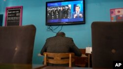 Телевизиотен екран показва китайския президент на посещение в Русия в кафене в Санкт Петербург, 20 март 2023 г.