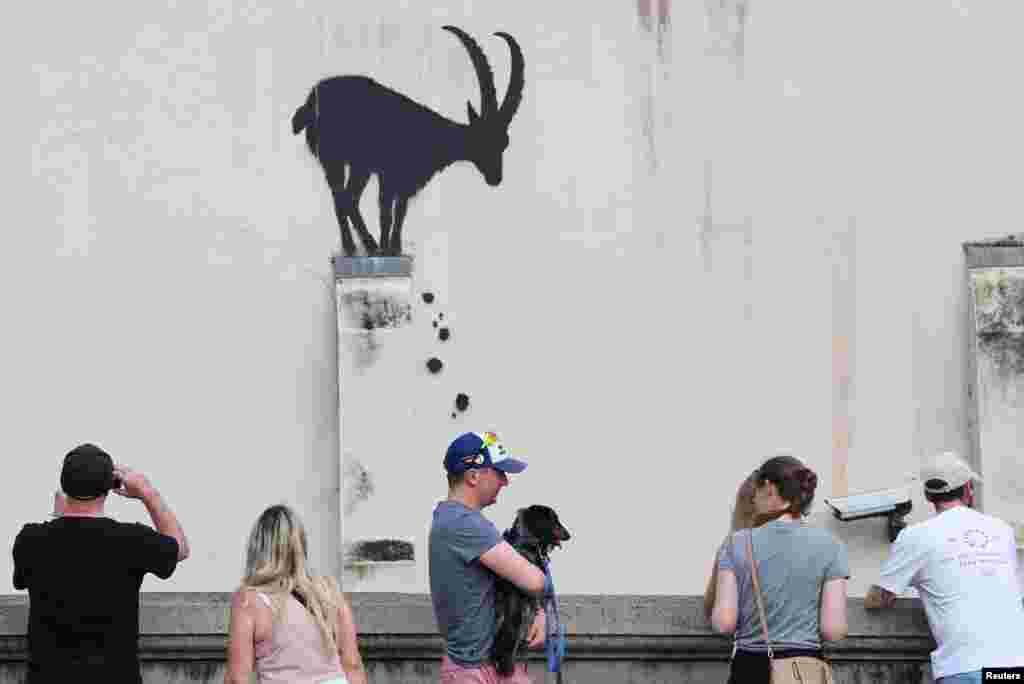 Njerëzit shikojnë një vepër të re arti nga artisti britanik Banksy, në Kew, në perëndim të Londrës, Britani, 5 gusht 2024.