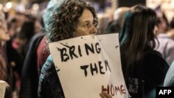 Демонстрантка тримає банер із написом «Поверніть їх додому», Тель-Авів, 9 грудня 2023 року