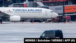 Policijski kombi na mjestu gdje je navodno otmičar u crnom automobilu parkiran ispod aviona turske kompanije na pisti aerodroma u Hamburgu, sjeverna Njemačka, 5. novembra 2023.