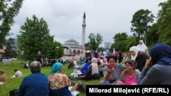 Posjetioci odmaraju na travnjaku ispred džamije Arnaudija neposredno pred ceremoniju otvaranja.