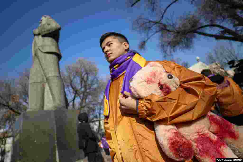 A man clutches a teddy bear covered in red paint to symbolize blood during a government-approved, anti-violence rally held in the Kazakh city of Almaty on November 26. Organized by the New People youth movement, roughly 300 people took part.&nbsp; The rally was dubbed &quot;Say No To The Animal World,&quot; with organizers likening violent people to animals.