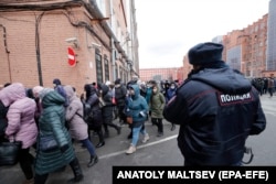 Рус полицияси ходими кўчада одамларни назорат қиляпти. Архив.