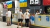 Refugees from Ukraine stop at the reception desk at an aid center in Warsaw in July 2022.