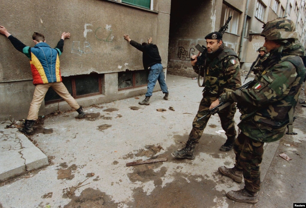 Ushtarët italianë ruajnë dy të dyshuar si zjarrvënës në Sarajevë në mars të vitit 1996. Dhjetëra mijëra trupa të NATO-s u vendosën gjatë konfliktit në Bosnje. Që atëherë, aleanca ka ndërhyrë edhe në Kosovë, Afganistan dhe në luftën civile të Libisë.