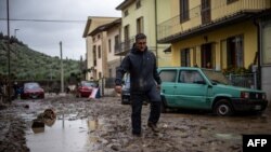 Мъж върви в калта в Монтемурло, близо до Прато, след проливен дъжд на 3 ноември 2023 г. Бурята "Киъран" връхлетя Тоскана късно на 2 ноември 2023 г., причинявайки смъртта на петима души според властите.