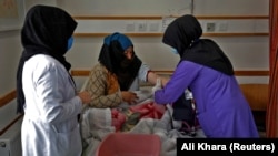 A trainee midwife examines a woman at a hospital in Bamiyan, Afghanistan, in March in a program spearheaded by the UN refugee agency with a local NGO.