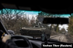 Украинский солдат едет по дороге на боевой бронированной машине БМП-1 на фоне нападения России на Украину в городе Авдеевке 17 октября