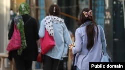 Women walk without the mandatory hijab in Iran.