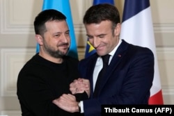 Macroni shtrëngon duart me presidentin e Ukrainës, Volodymyr Zelensky, gjatë një konference për shtyp në Paris, më 16 shkurt, pas nënshkrimit të një marrëveshjeje dypalëshe për sigurinë.