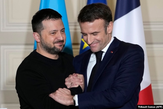 Macroni shtrëngon duart me presidentin e Ukrainës, Volodymyr Zelensky, gjatë një konference për shtyp në Paris, më 16 shkurt, pas nënshkrimit të një marrëveshjeje dypalëshe për sigurinë.