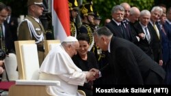 Hungarian Prime Minister Viktor Orban (right) greets Pope Francis, sitting beside Hungarian President Katalin Novak, at a reception held at Buda Castle on April 28.