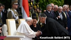 Orbán Viktor miniszterelnök köszönti Ferenc pápát a Szent György téren tartott fogadáson 2023. április 28-án. Középen Novák Katalin köztársasági elnök. A katolikus egyházfő háromnapos apostoli látogatásra érkezett Magyarországra
