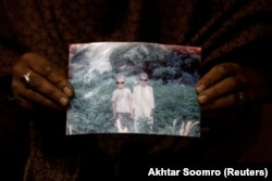 Zahra Ramzan holds a picture of her 11-year-old son, Ali Mohammad (left), who was swept away.