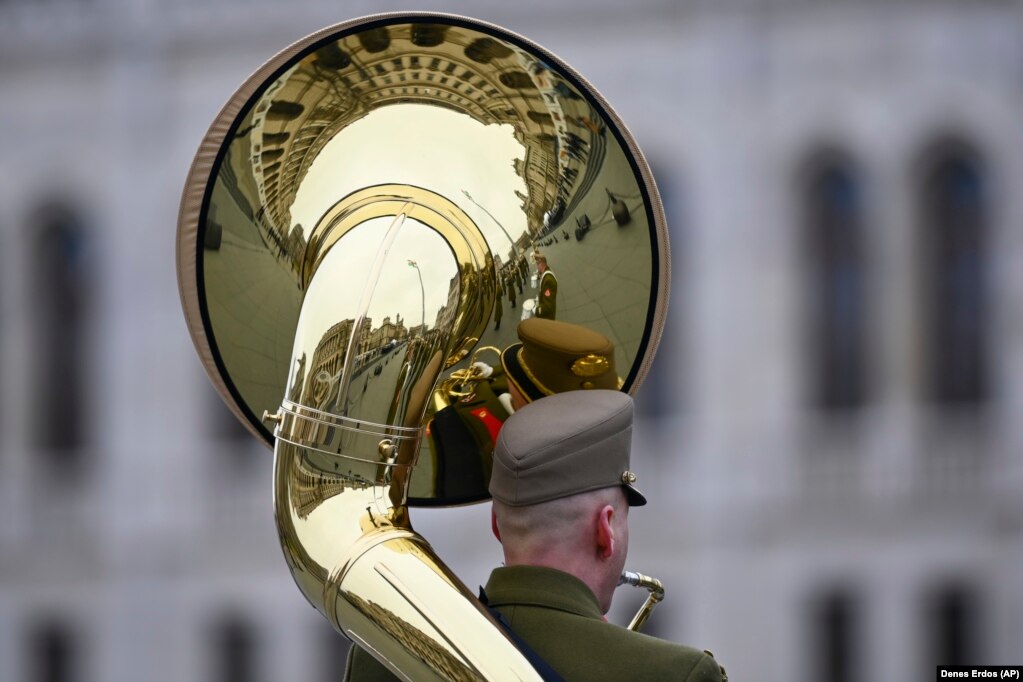 Një anëtar i bandës ushtarake hungareze duke luajtur në instrumentin e tij  përpara ndërtesës së Parlamentit në Budapest.