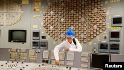 Гид показывает аварийную кнопку на закрытой Игналинской АЭС, Литва. Архивное фото