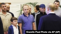 Russian President Vladimir Putin (foreground, right) speaking with the group of Russians returned from Western incarceration in a historic prisoner swap on August 1. Accused Russian-Spanish spy Pablo Gonzalez, who roamed the EU and South Caucasus as a journalist, stands in the background, second from left.