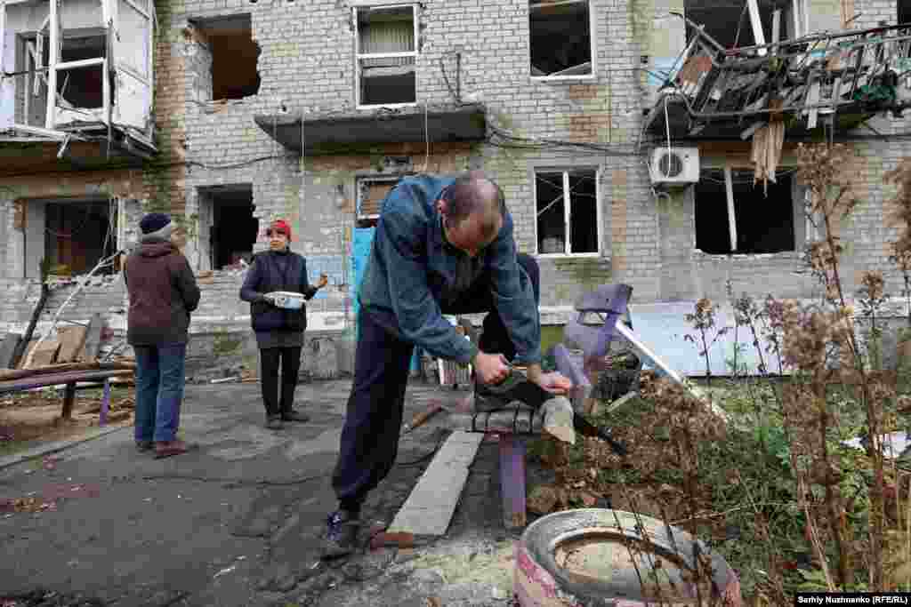 Local resident Oleksandr saws firewood. Though Avdiyivka has an &quot;invincibility point&quot; -- a&nbsp; humanitarian support center offering food, warmth, power, and refuge -- it has become extremely dangerous for residents to venture to.