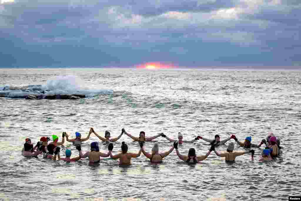 Skupina ljudi, najviše žena, koja sebe naziva "Endorfini", na kupanju tokom izlaska sunca u prohladnim vodama jezera Ontario u Torontu, Kanada, 17. januara.