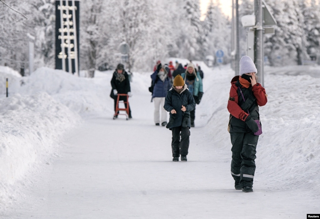 Njerëzit duke shëtitur në borë në qytetin e Akaslompolos, në Finlandë më 4 janar 2024.