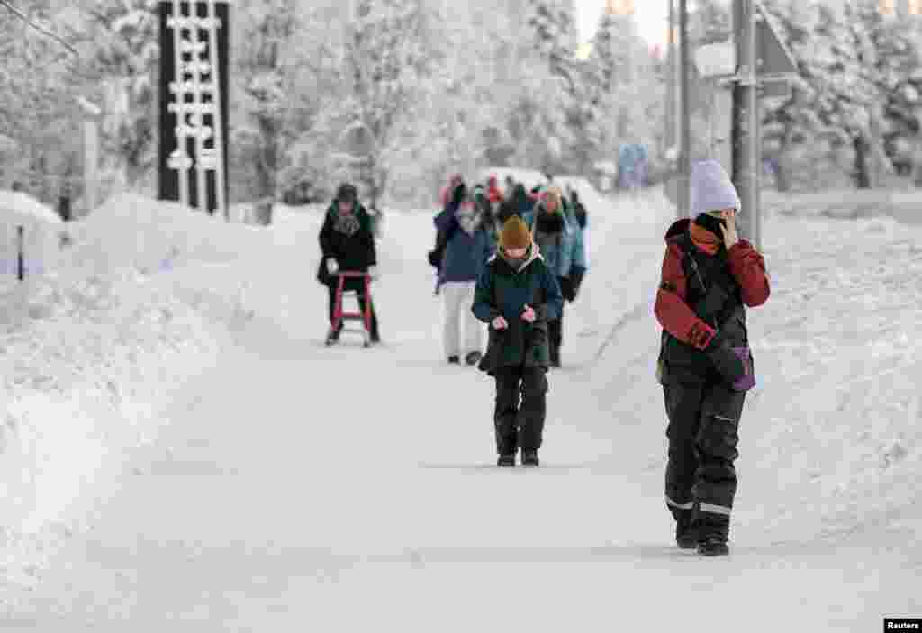 Njerëzit duke shëtitur në borë në qytetin e Akaslompolos, në Finlandë më 4 janar 2024.