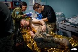 „Az életmentést a felcserek végzik.” Sebesült katonát látnak el Bahmut közelében egy ukrán egészségügyi stabilizációs ponton 2023. május 5-én