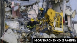 Рятувальники прибирають уламки пошкодженого російським дроном житлового будинку в Одесі, 3 березня 2024 року