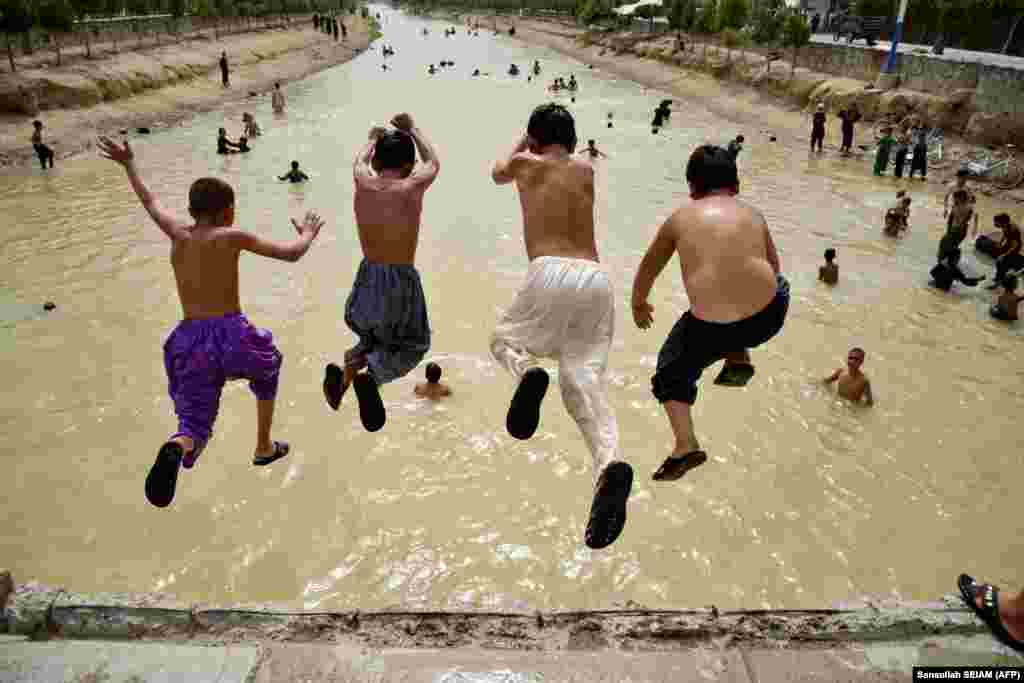 Afghan boys jump into a canal on the outskirts of Kandahar Province.