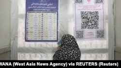 Žena proverava imena kandidata na parlamentarnim izborima na biračkom mestu u Teheranu, 1. mart 2024. 