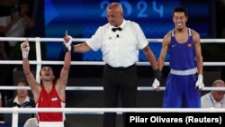 Abdumalik Halokov (left) of Uzbekistan celebrates winning the gold medal against Kyrgyzstan's Munarbek Seiitbek-uulu in Paris.