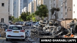 Kiégett járművek az izraeli Askelónban 2023. október 7-én, miután hajnalban rakétákkal lőtték az izraeli területeket a Gázai övezetből, a palesztin Hamász fegyveresei pedig behatoltak Izraelbe