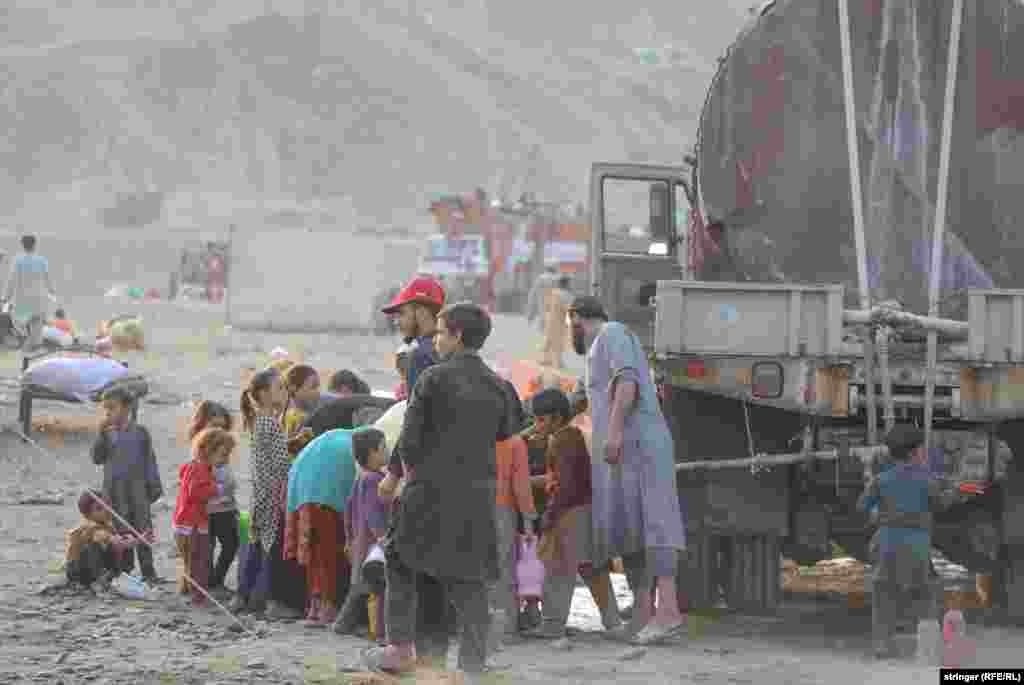 &nbsp;Afghan children gather water near a truck. &nbsp;