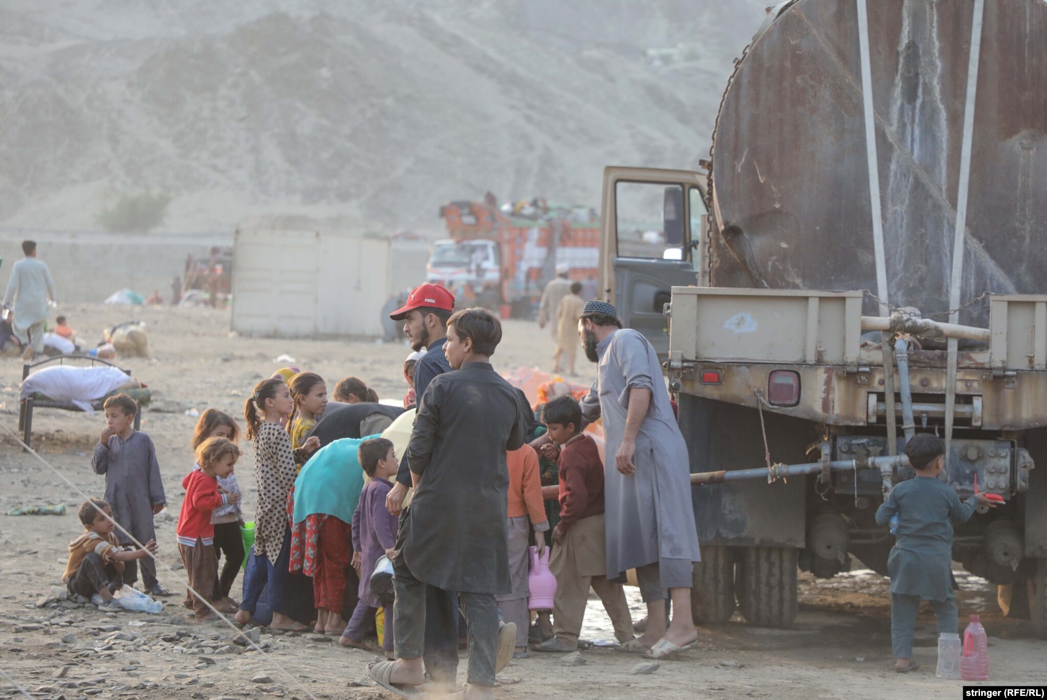 &nbsp;Afghan children gather water near a truck. &nbsp;