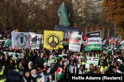 Protestatri cu pancarte pro-palestiniene la marșul de sâmbătă de la Londra.