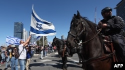Lovas rendőrök állnak szemben a jogrendszer átalakítása ellen tüntetőkkel Tel-Avivban 2023. március 9-én