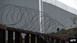 Čovjek prelazi granicu Meksika i SAD-a između Tihuane i San Dijega, kroz propust u pograničnim barijerama, 28. septembar 2023.