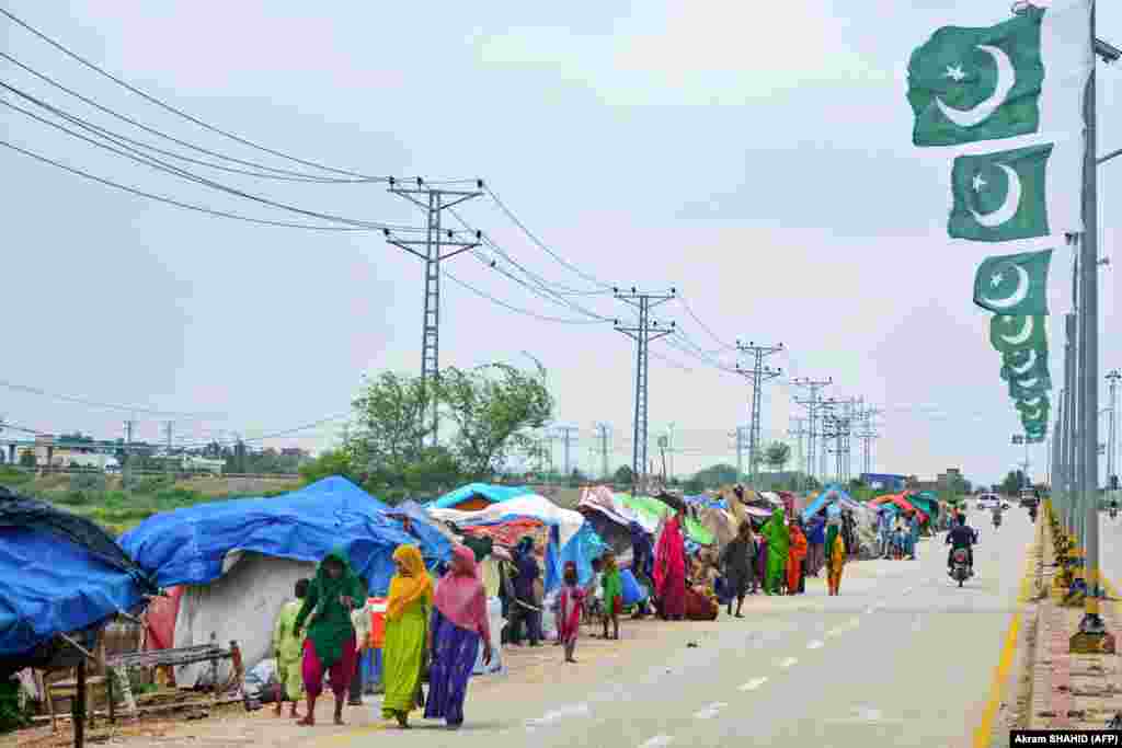 Flood-affected people walk past makeshift tents on a roadside after heavy monsoon rains in Hyderabad. Rain also triggered flash floods in the port city of Karachi, causing power outages, media reported. &nbsp;