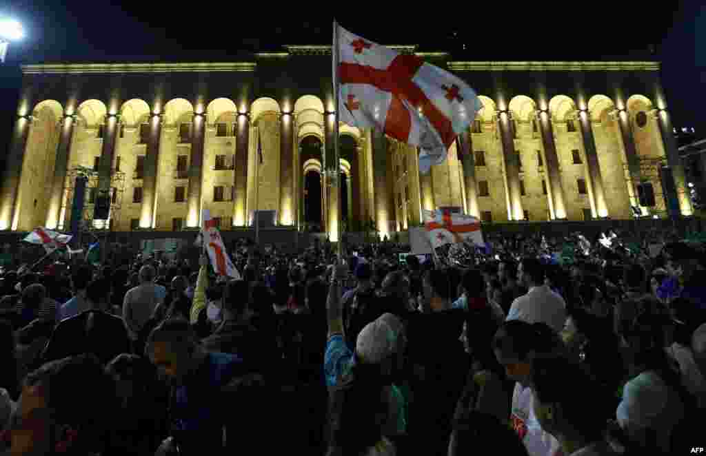 Demonstranti drže zastavu Gruzije ispred gruzijskog parlamenta na mitingu protiv zakona o &quot;stranim agentima&quot;, za koji Brisel upozorava da bi mogao otežati evropske integracije Gruzije, Tbilisi 1. maja 2024.