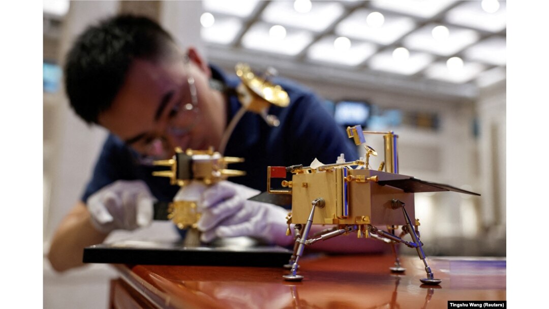 A China National Space Administration staff member assembles a model of the Chang'e 6 lunar probe ahead of a June press conference about China's lunar exploration program.