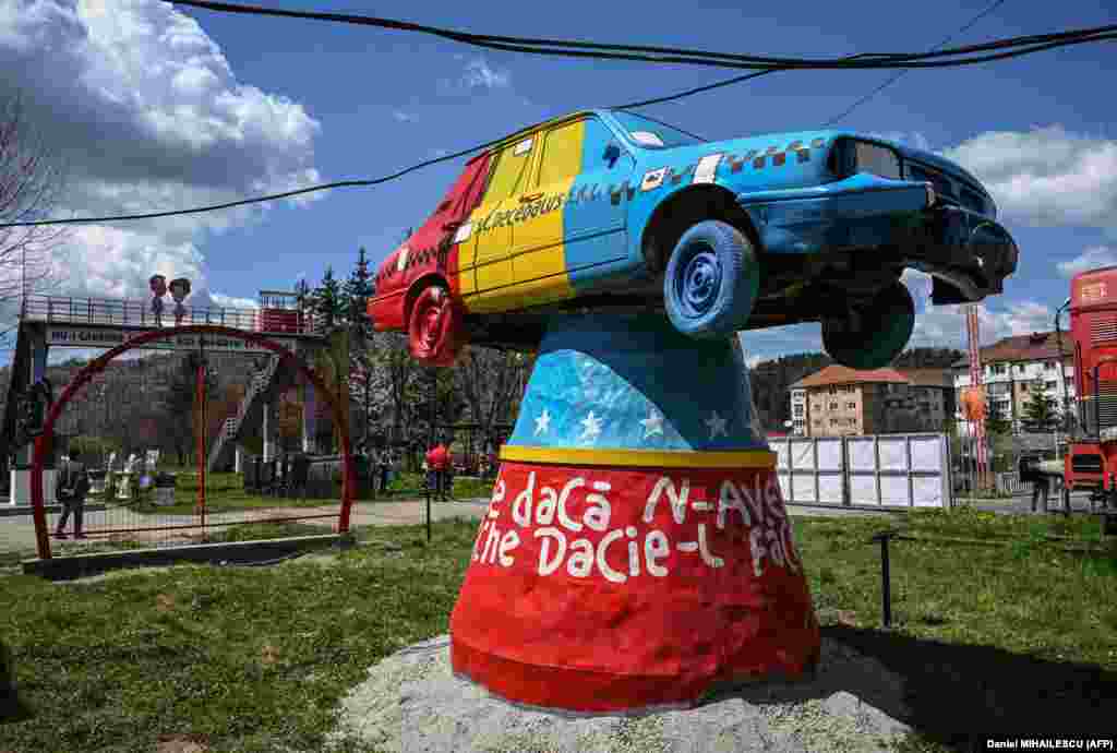 An installation made by visual artist Ion Barbu, representing a communist-era Dacia car painted in the colors of the Romanian flag and reading, &quot;If we don&#39;t have a Dacia, we will make it from a Porsche,&quot; is seen on the site of the closed coal mine in Petrila, Romania.