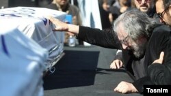 Iranian director Masoud Kimiaei grieves over the coffin of Dariush Mehrjui at the October 18 funeral for the filmmaker and his wife, who were stabbed to death over the weekend.