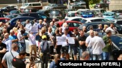 На "спонтанното" полицейско събиране присъстваха и малка група граждани с еднотипни плакати в защита на министър Стоянов, 12 август 2024 г.