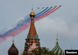 Avioane de luptă Su-25 eliberează fum în culorile drapelului rusesc deasupra Catedralei Sfântul Vasile, Moscova, Rusia, 9 mai 2024.